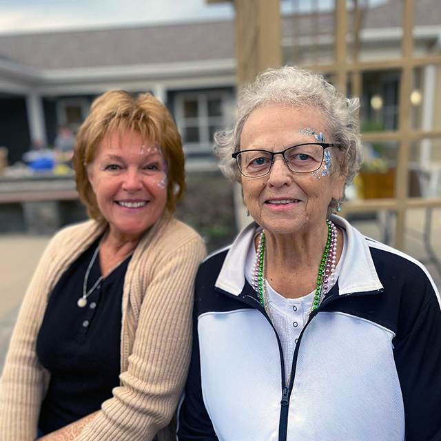 A resident smiles alongside a loved one at Rock Creek Senior Living.